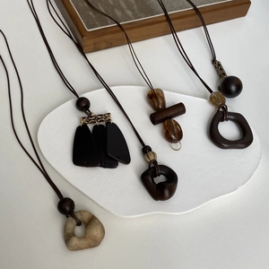 Macro detail of bohemian brown tassel necklaces with wooden beads and resin pendants