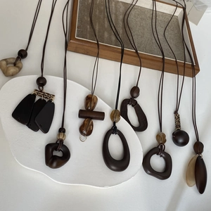 Flat lay of minimalist brown resin pendants with marble patterns and long cords
