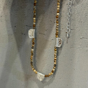 Detail einer Ethno-Natursteinkette mit gravierten silberfarbenen Metallelementen