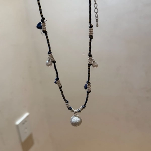Detailansicht der gewebten Boho-Halskette mit Lapislazuli-Steinen und mattem Silberanhänger