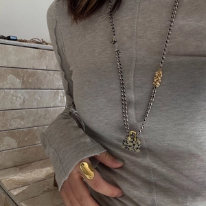 Minimalist tiger eye stone necklace with gold ring and tassel on a grey sweater model