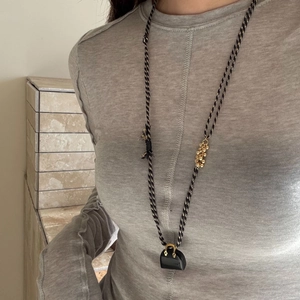 Minimalist long sweater necklace with black purse pendant and tiger eye bead accents