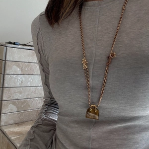 Minimalist tiger eye stone necklace with a handbag-shaped bead pendant on a woven cord