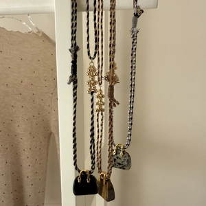 Detail of woven necklaces with tiger eye stone handbag pendants and golden metallic beads