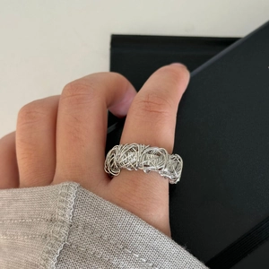 Detail of silver plated intertwined wire mesh ring with an artistic hollow geometric design