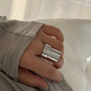 Close-up of a wide polished silver geometric hollow ring on finger for modern style