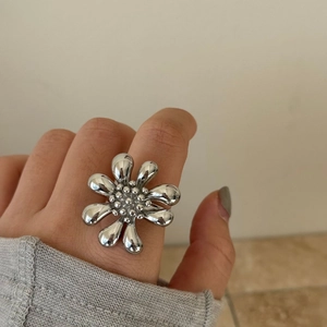Detailed view of silver open ring featuring a unique hollow flower design and petals