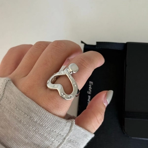 Silver wide-band heart open ring with industrial nail detail worn on finger