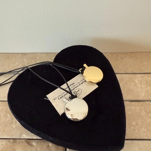 Minimalist oval pendant necklaces in gold and silver finish on a black heart tray