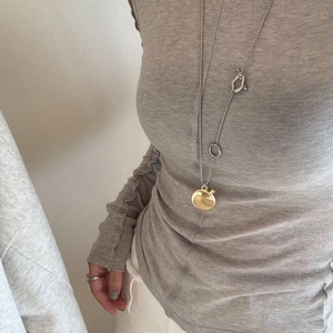 Detail of vintage silver long chain necklace with a unique golden oval pendant