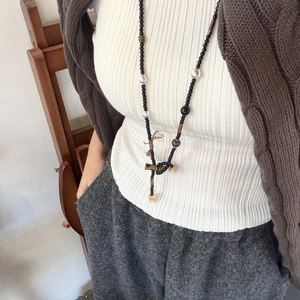 Nahaufnahme einer langen Perlenkette mit Achat, Tigerauge und Holzkreuz am Modell