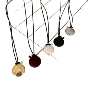 Minimalist oval pendant necklaces in assorted matte and glossy finishes on black cords