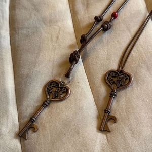 Vintage bronze butterfly key pendant necklace with brown cord and intricate relief detail
