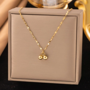 Detailaufnahme des goldenen Anhängers auf Seidenhintergrund mit eleganter Wasserwellenkette