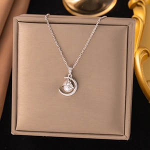 Detailed close-up of crescent moon pendant with pearl and micro-inlaid zircon stones