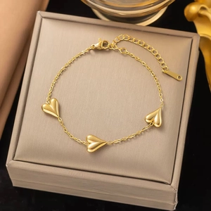 Detailed view of a gold stainless steel bracelet with three 3D heart charms and clasp
