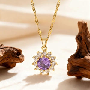 Macro shot of gold floral necklace with a round purple zircon stone and white pavé setting