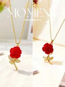 Detailed close-up of a red rose pendant with gold leaf accents and zircon stones