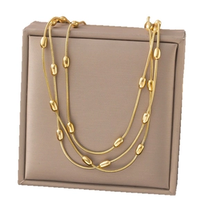 Elegant layered gold snake chain necklace featuring polished oval metal beads decor