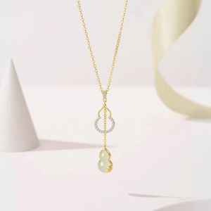 Collana di lusso in titanio dorato con ciondolo a doppia zucca in calcedonio su sfondo minimal