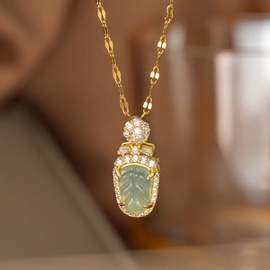 Makroaufnahme eines hellgrünen Chalcedon-Anhängers mit Zirkonia-Besatz an einer Goldkette