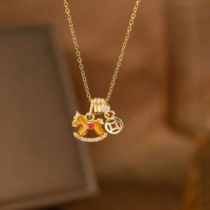 Golden rocking horse pendant necklace with ancient coin charm and red zircon accents