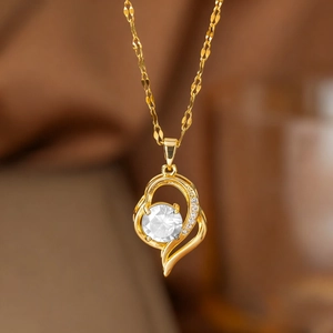 Dettaglio della collana a cuore dorata con vortice asimmetrico e pietra di zircone