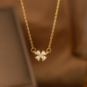 Detailed close-up of golden laurel necklace with pear-cut zirconia clover pendant