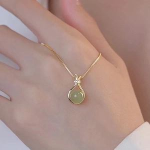Collana dorata elegante con ciondolo tondo in pietra preziosa verde chiaro e piccoli diamanti brillanti