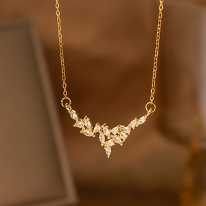 Detail of gold laurel leaf pendant with marquise and pear cut crystals on a thin chain