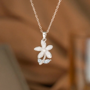 Elegant daisy flower pendant necklace with white enamel petals and a small pearl center