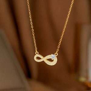 Makroaufnahme der goldenen Infinity-Halskette mit funkelnden Zirkoniasteinen im Detail
