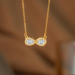 Detailansicht der Unendlichkeits-Halskette in Gold mit birnenförmigen Kristallen und Pavé