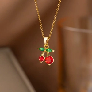 Collier cerise doré élégant avec zircons rouges ronds et pierres précieuses feuilles vertes