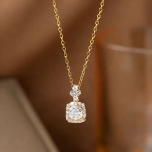 Elegant gold chain necklace featuring a square cut clear gemstone with diamond halo pendant