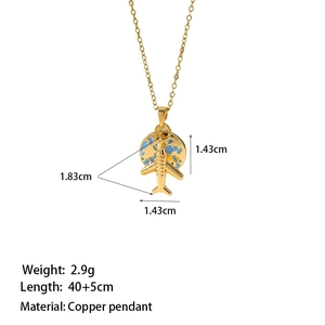 Vue détaillée du collier de voyage avec avion doré et pendentif globe en émail bleu
