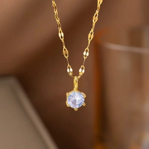 Macro shot of gold-plated necklace featuring a six-prong set sparkling zircon pendant