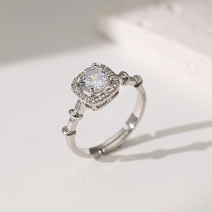 Détail d'une bague en argent avec une pierre centrale ronde en zircon et halo