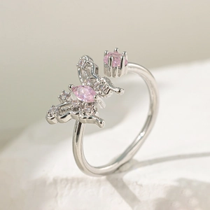 Détail d'une bague papillon argentée avec pierres roses et micro-pavage de zircons