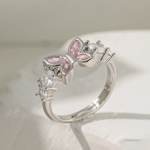 Détail d'une bague papillon argentée ornée de pierres roses et éclats de zircon