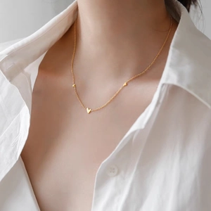 Collier en titane doré élégant avec mini breloques cœur sur chaîne fine raffinée