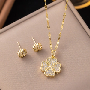 Macro shot of 18K gold clover jewelry set with sparkling pavé crystals and fine chain