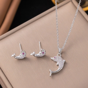 Macro detail of silver dolphin jewelry set with micro-pave crystals and purple accents