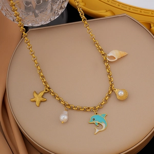 Detail of gold ocean theme necklace with starfish, dolphin and pearl charms on a display