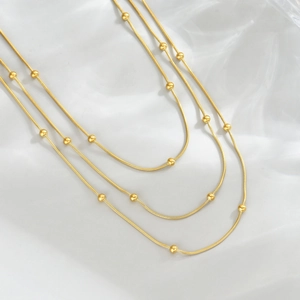 Collier triple rang en acier titane doré avec perles et chaîne serpent chic