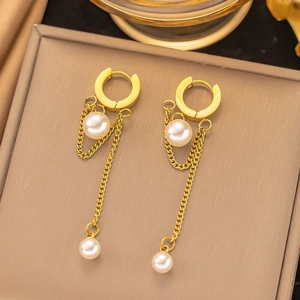 Close-up of elegant gold chain drop earrings with white pearls and snap closure