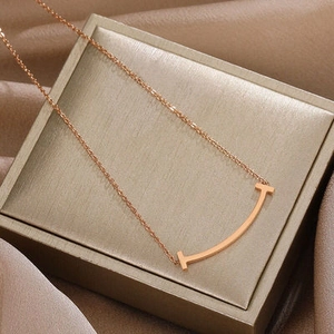 Detalle del colgante de cara sonriente en oro rosa sobre un joyero con tela de seda