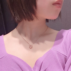 Collar de estrella en oro rosa con colgante de circón usado por una modelo con ropa de punto