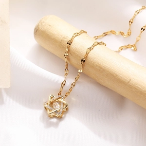 Elegante collar con colgante de hexagrama dorado y circón brillante sobre madera