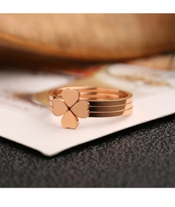 Three-in-one rose gold stainless steel clover heart ring set shown on white surface